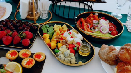 Colorful catering buffet displaying vibrant selection of fresh fruits, artisan cheeses, crisp...