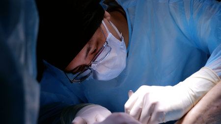 Skilled surgeon in an operating room uses technology and expertise to perform a critical life saving procedure, showcasing the crucial role of skill and innovation in healthcareの写真素材