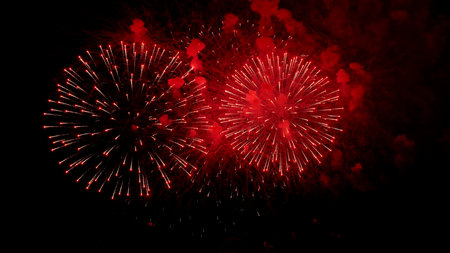 bright explosions light up night, dynamic fireworks create energetic visual for celebrations, intense bursts of crimson fireworks add vibrant excitement to festive promotional materialの写真素材