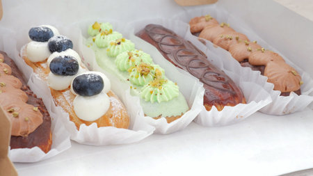 Colorful festival eclair assortment in trays with mixed toppings, street market vibe, vibrant hues,...