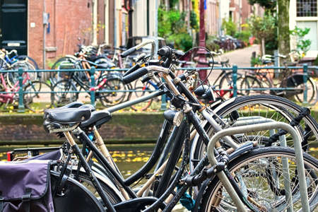 Bicycles parked on both sides of a canal in Amsterdam, Netherlandsの写真素材