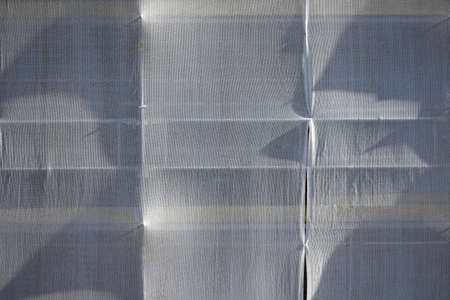 Dust protection net installed on the scaffolding of a building under constructionの写真素材
