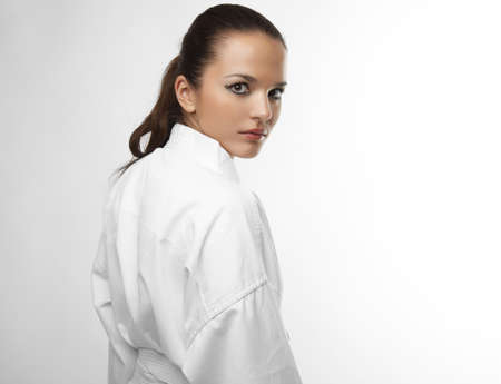 Attractive young sexy women in a karate pose isolated on whiteの写真素材