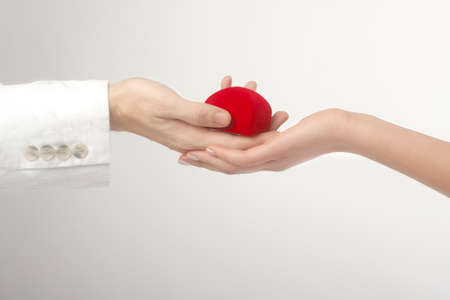 The man's hand gives present to a female hand isolated on whiteの写真素材