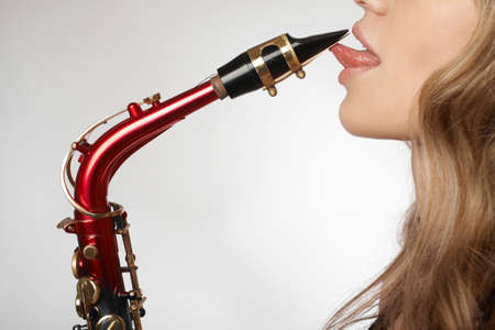 Sexy attractive women with saxophone isolated on white background