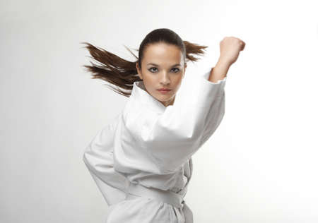 Attractive young sexy women in a karate pose isolated on white
