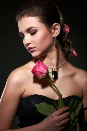 female portrait with rose on black backgroundの写真素材