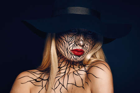 fashion portrait of girl with faceart and red lips. Picture taken in the studio on a black background.の写真素材