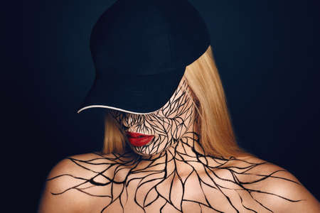 fashion portrait of girl with faceart and red lips. Picture taken in the studio on a black background.の写真素材