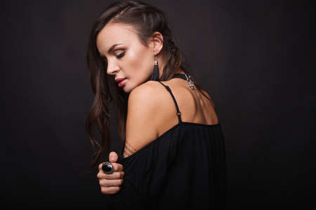 Studio portrait of a sexy brunette in black dressの写真素材