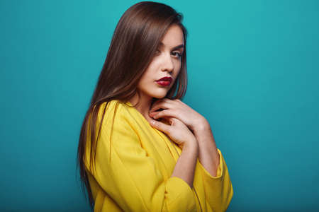 Portrait of fashion glamor stylish swag young woman in yellow coat  on bright background