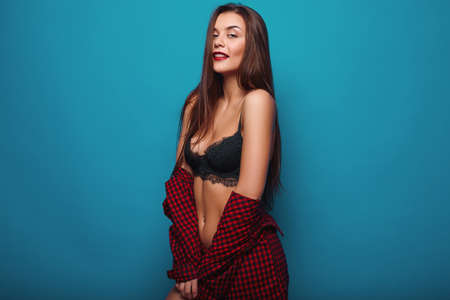 Portrait of fashion glamor stylish swag young woman in red shirt on bright backgroundの写真素材