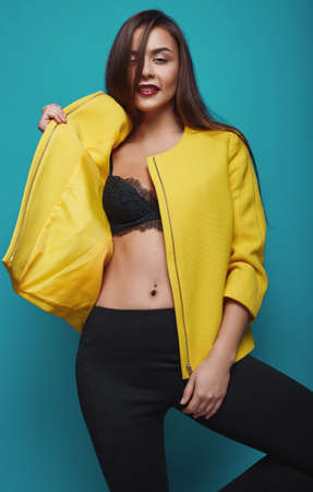 Portrait of fashion glamor stylish swag young woman in yellow coat  on bright backgroundの写真素材