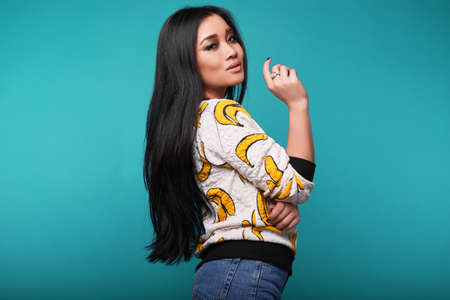 Fashion swag portrait of beautiful elegant asian woman in funny banana t-shirt on bright backgroundの写真素材