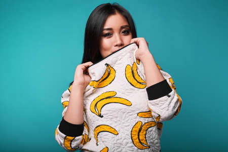 Fashion swag portrait of beautiful elegant asian woman in funny banana t-shirt on bright backgroundの写真素材