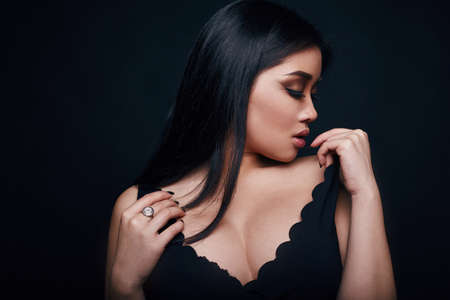Fashion swag portrait of beautiful elegant asian woman in formal dress on black backgroundの写真素材