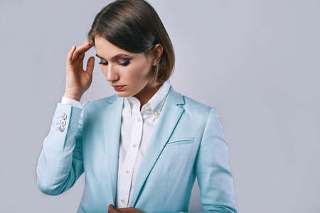 fashion portrait of young elegant woman in azure man jacket in studioの写真素材