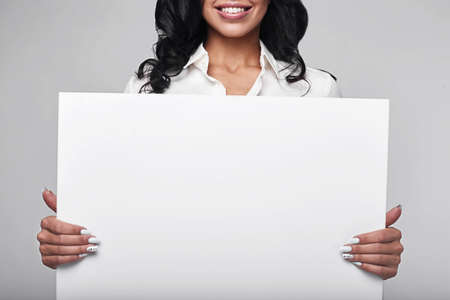 Portrait of a happy business woman holding baner on white background