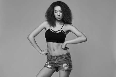 Sensual portrait of glamor elegant black woman model with curly hair posing on a gray background in studioの写真素材