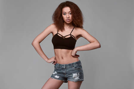Sensual portrait of glamor elegant black woman model with curly hair posing on a gray background in studioの写真素材