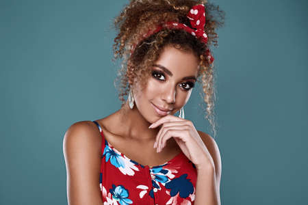 Sensual bright portrait of glamor elegant black woman model with curly hair in red dress posing on...