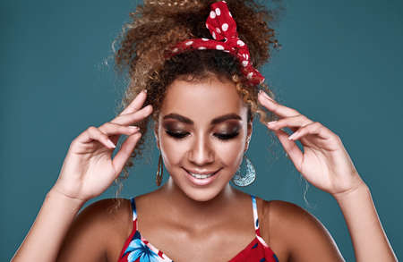 Sensual bright portrait of glamor elegant black woman model with curly hair in red dress posing on...