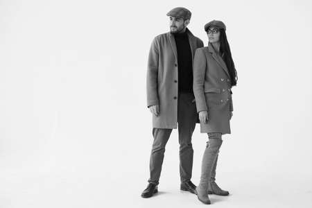 Beautiful portrait of a loving couple dressed in a yellow fashion coat isolated on white background in studioの写真素材