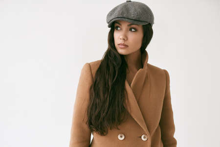 Portrait of beautiful glamor brunette woman wearing coat isolated on white background in studio