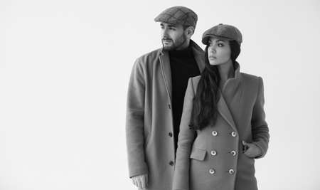 Beautiful portrait of a loving couple dressed in a yellow fashion coat isolated on white background in studioの写真素材
