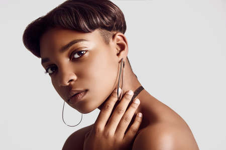 Close-up sensual portrait of young beautiful hipster black girl with short hair isolated on white...
