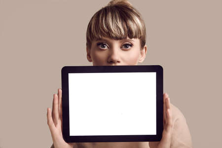 Close-up portrait of beautiful glamour blond hipster woman with digital tablet. Studio shootの写真素材
