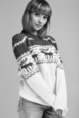 Portrait of beautiful blond woman with short hair in christmas sweater. Studio shoot.の写真素材