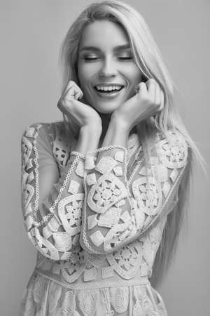 Portrait of gorgeous sensual blonde woman in fashion dress posing on pink background in studioの写真素材