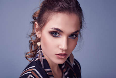 Sensual portrait of elegant glamor woman in fashion suit posing on colorful blue background in studioの写真素材