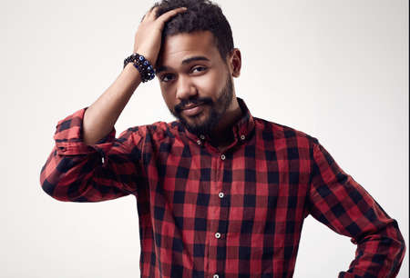Isolated portrait of fashionable brutal young African American male hipster in red casual shirt