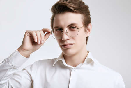 Portrait of confident young handsome businessman in shirt isolated on white background in studio
