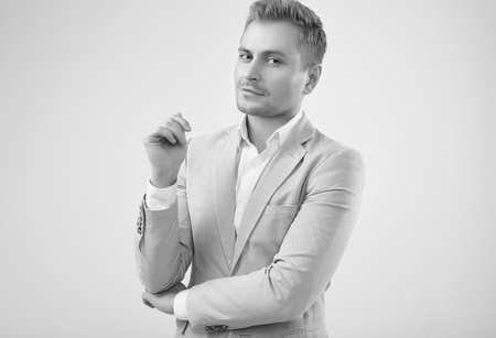 Portrait of a handsome blonde man model in a fashion gray suit isolated on white background in studioの写真素材
