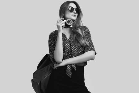 Portrait of young beautiful woman with backpack and camera ready to travel. Smiling student girl...