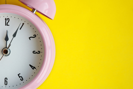 alarm clock on yellow background, closeup, blank for designersの写真素材