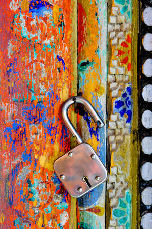 An unlocked lock hanging on the colorful wall of Buddhist monastary in Ladakhの写真素材