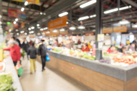Blurred image of people shopping in an indoor food market for background usage.