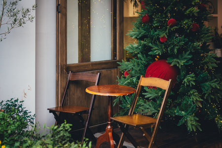 Wooden chairs and a Christmas tree on the background of a windowの写真素材