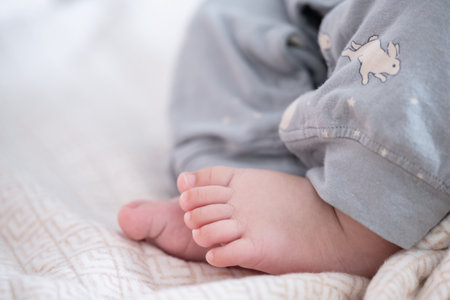 Close up of the feet of a newborn baby lying on a blanket