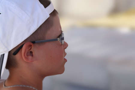 the boy on the blue sky looks into the distanceの写真素材