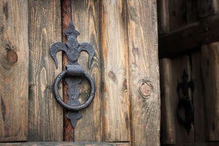 vintage iron handle in the form of a ring on a wooden doorの写真素材