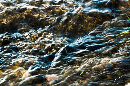 Beautiful clear creek stream water flowing over rocks babbling brookの写真素材