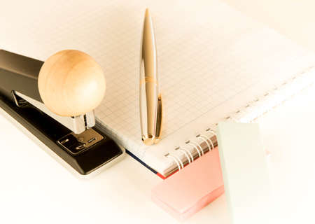 Silver handle with gold inserts papers for writing on a white background. stationery set on a light...
