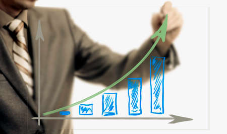 Businessman drawing rising graph, development and growth concept, increase of positive indicators in entrepreneurship.の写真素材