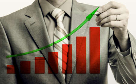 Businessman drawing rising graph, development and growth concept, increase of positive indicators in entrepreneurship.の写真素材