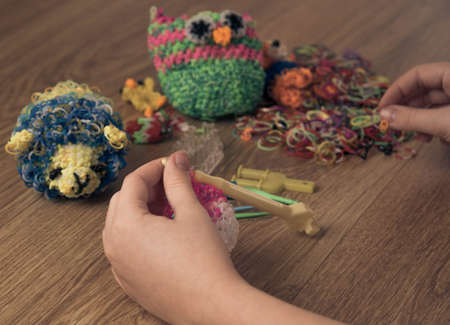 children's hands are weaving figures out of colored rubbersの写真素材